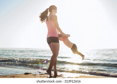 Mother And Daughter Having Fun On Beach