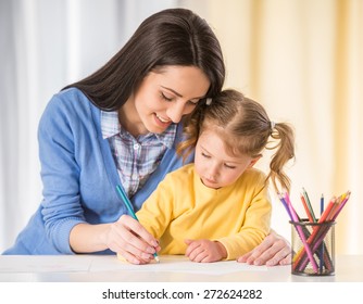 Mother   daughter are having fun while drawing at home 