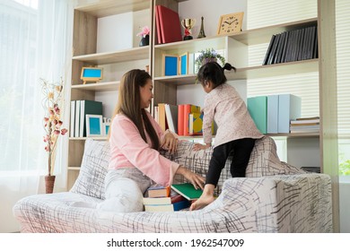 Mother and daughter helped organize the house. By organizing books on the bookshelf in the living room - Powered by Shutterstock