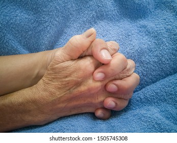 Mother And Daughter Are Holding Hands On Blue Blanket While Stay In Hospital. Close-up Image. Palliative Care Concept. 