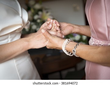 Mother And Daughter Holding Hands On Her Wedding Day