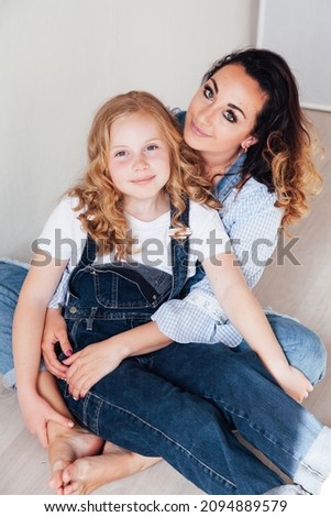 mother and daughter in jeans hug