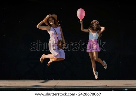 Image, Stock Photo Happy women jumping in front of garden fence