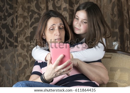 Mother and daughter in living room arguing and holding tablet