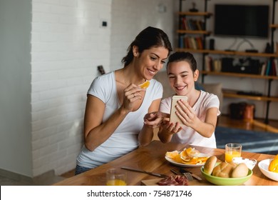 Mother And Daughter Looking At Mobile Phone