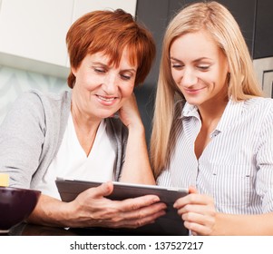 Mother And Daughter Looking In Tablet Pc. Two Women With Tablet Computer. Family At Home