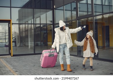 Mother And Daughter With Luggage Going From Airport Terminal