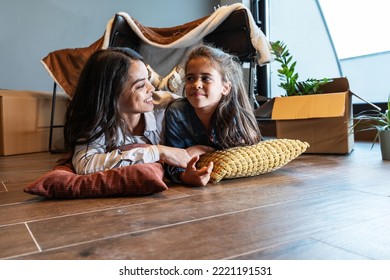 Mother And Daughter Lying Down In Front Of The Improvised Tent In The Living Room.	
