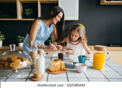 Mother And Daughter Making Breakfast Together At Home