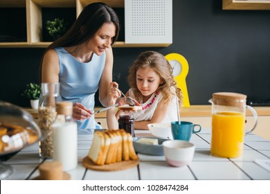 Mother And Daughter Making Breakfast Together At Home