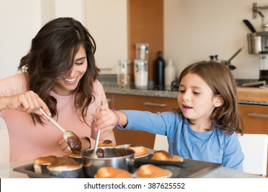 Mother and daughter making cupcakes in kitchen - Powered by Shutterstock