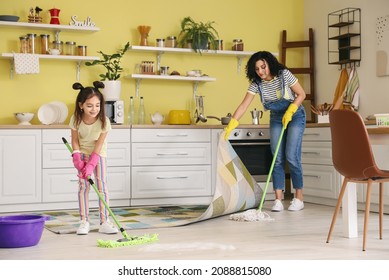 Mother And Daughter Mopping Floor In Kitchen