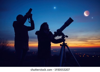 Mother and daughter observing stars, planets, Moon and night sky with astronomical telescope. - Shutterstock ID 1930553207