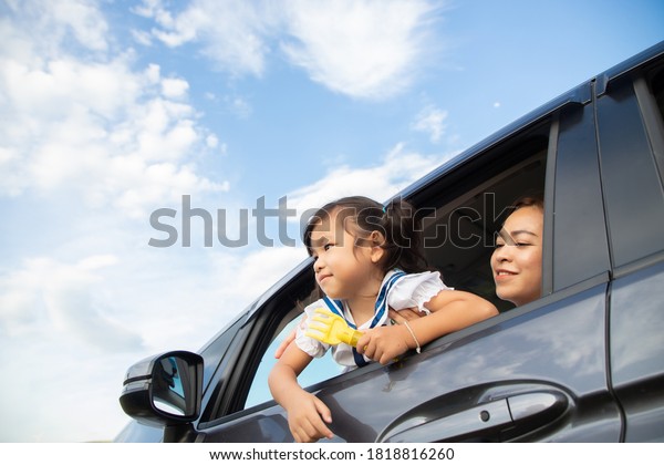 Mother and daughter on car and smile from\
car,  family travel trip in holiday, this image can use for family\
, travel, car, weekend, and summer\
concept