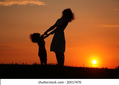 Mother and daughter on sunset watching on sky