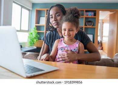 Mother and daughter on a video call with doctor.