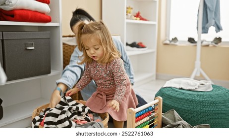 A mother and daughter organize clothes in a bright, messy room, reflecting family, childcare, and domestic life. - Powered by Shutterstock