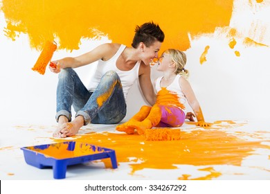 Mother And Daughter Painting A Wall Together