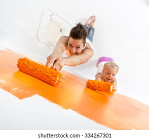 Mother And Daughter Painting A Wall Together