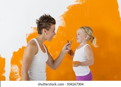 Mother And Daughter Painting A Wall Together