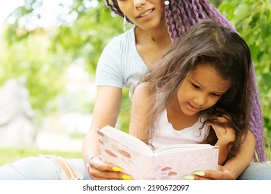 Mother And Daughter In The Park Reading A Book, Back To School, Parent With Child, African Family Outside