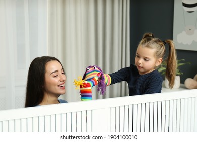 Mother And Daughter Performing Puppet Show At Home