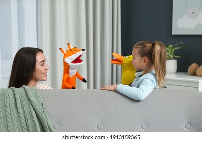 Mother And Daughter Performing Puppet Show At Home