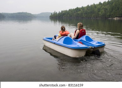 Mother and daughter pladdleboating on a lake