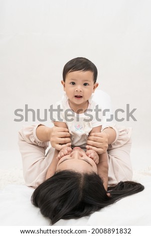 Mother and daughter playfully tease each other on white background.Concept of the importance of raising children to grow up. 