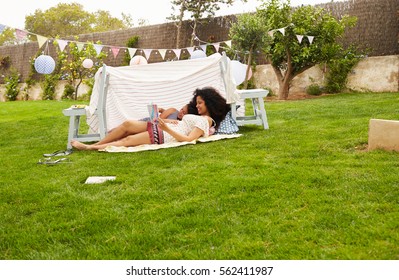 Mother And Daughter Playing In Home Made Garden Den