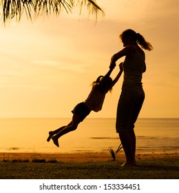 Mother And  Daughter Playing On The Beach