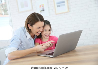 Mother And Daughter Playing On Laptop Computer