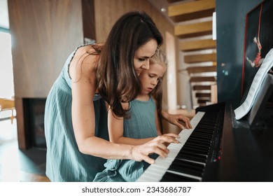 Mother and daughter playing on piano together. - Powered by Shutterstock