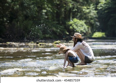 Mother and daughter playing in the river