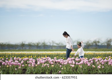 Mother and daughter playing in a tulip field