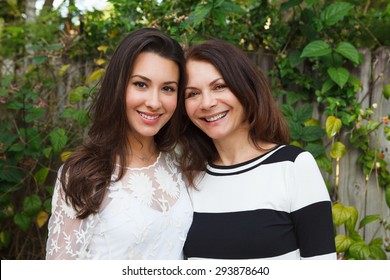 Mother And Daughter Portrait In A Outdoor Setting.