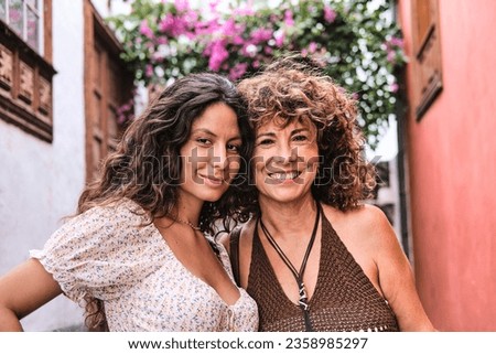 Mother and daughter pose in a charming corner in an old village