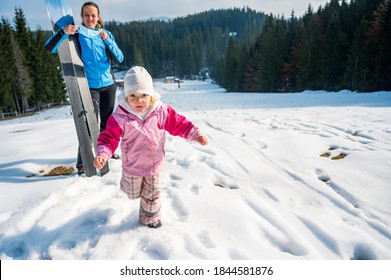 Mother and daughter posing at ski resort prepared to ride slopes.