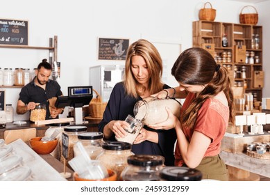 A mother and daughter pour rice from a dispenser into a glass jar at a zero-waste bulk store, with the shopkeeper managing inventory in the background. - Powered by Shutterstock