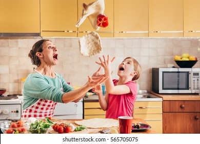 Mother and daughter preparing pizza in the kitchen - Powered by Shutterstock