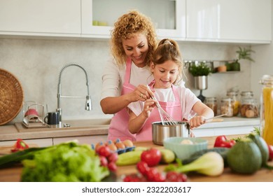 Mother and daughter preparing tasty food at home - Powered by Shutterstock