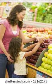 Mother And Daughter In Produce Section Of Supermarket