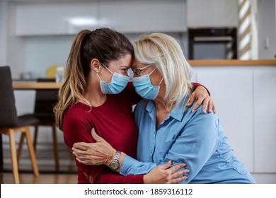 Mother and daughter with protective surgical face masks on sitting on the floor and hugging during corona virus outbreak. Even it is corona outbreak we still can share love. - Powered by Shutterstock