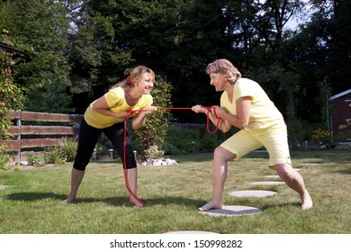 Mother And Daughter Pulling A Rope