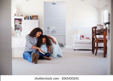 Mother and daughter reading a book in girl's room - Powered by Shutterstock