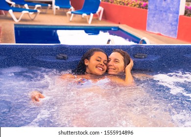 Mother And Daughter Relaxing In Private Jacuzzi. People Smiling For A Summer Day. Travel, Summer And Family Concept.