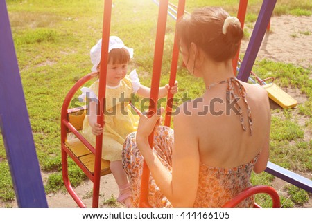 Mother and daughter ride seesaw