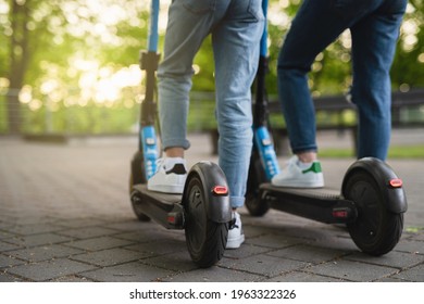 Mother and daughter riding electric scooters in city park - Powered by Shutterstock