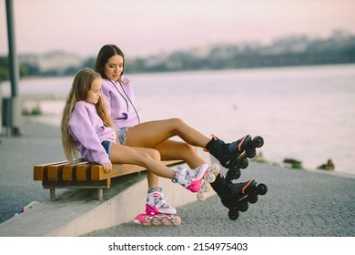 Mother with daughter rollerskating in park with lake