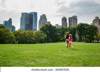 mother and daughter running away on the grass in the park